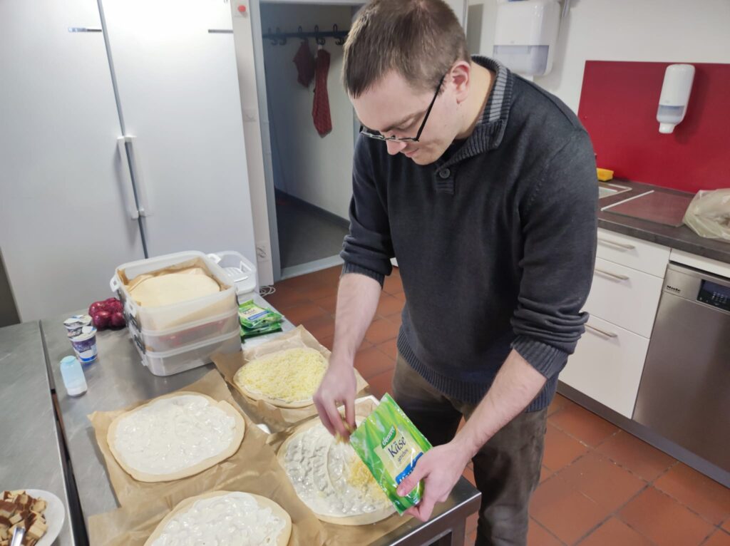 Ein Informatiker belegt die Pizzen mit Käse (KI-Rezept)